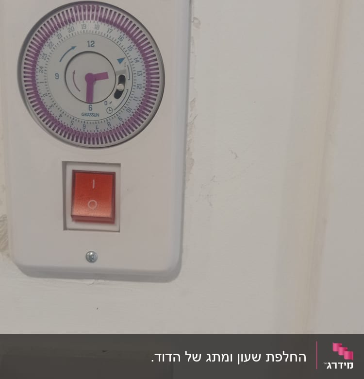 שעון טיימר חשמלי ומתג הפעלה על קיר